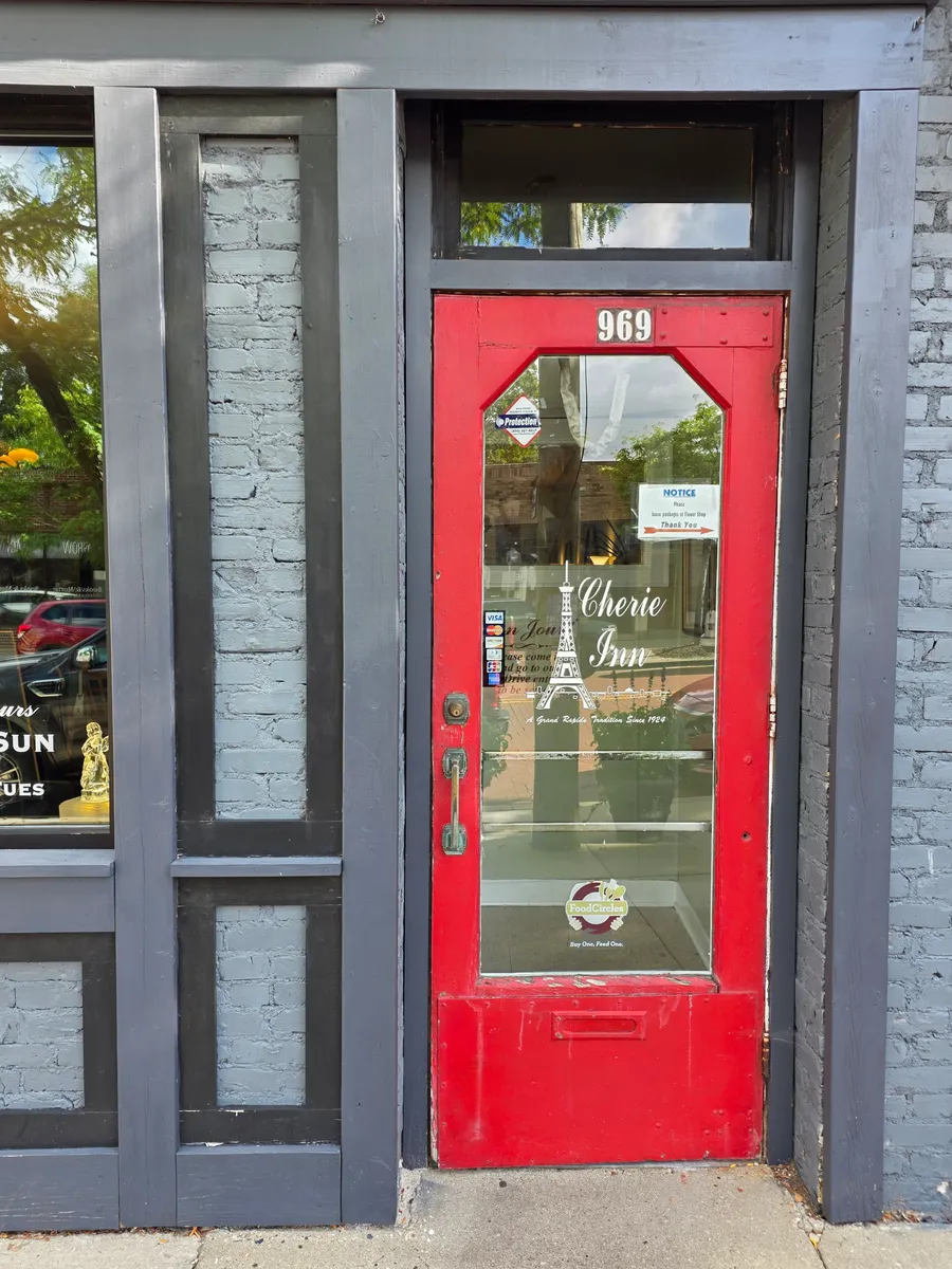 Cherie Inn’s red front door at 969 Cherry St SE, etched “A Grand Rapids Tradition Since 1924”